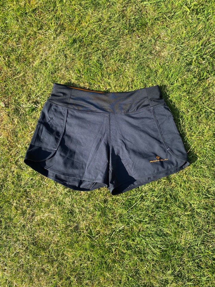 Black running shorts on grass.