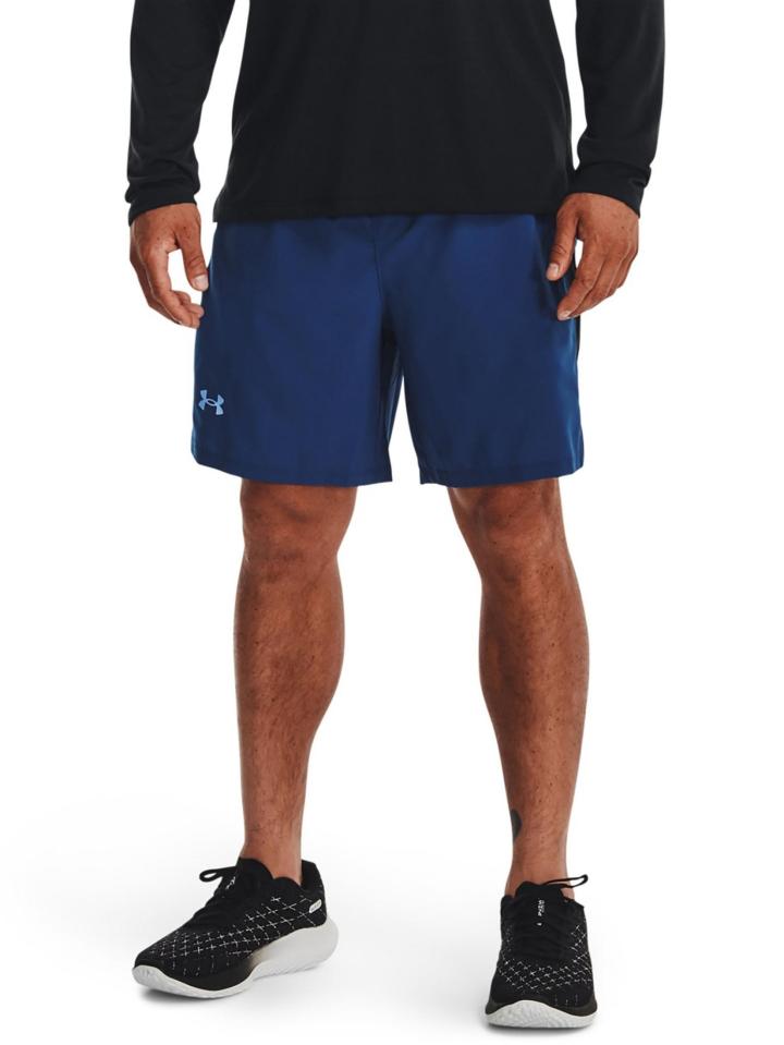 Man wearing blue Under Armour shorts and black shoes.