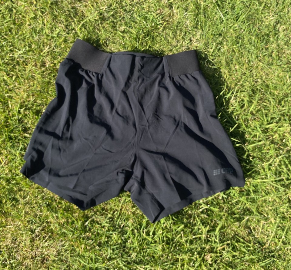 Black running shorts on grass.