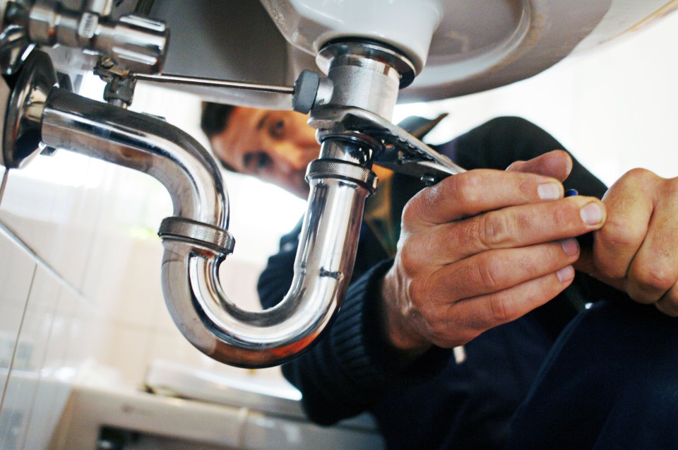 Close-up of a plumber repairing a sink.