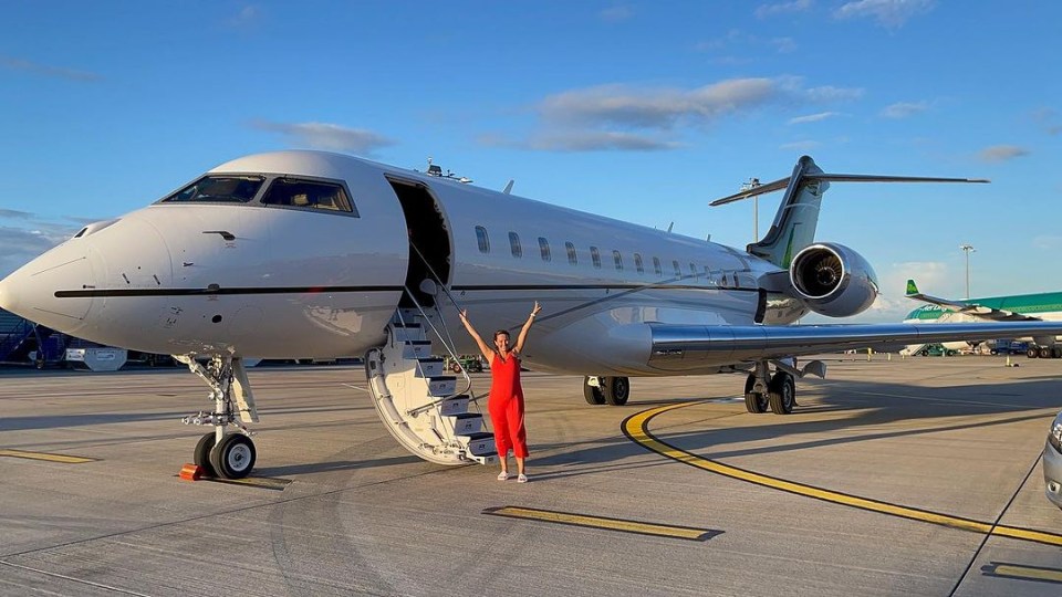 Dee was all smiles as she posed outside the luxury jet