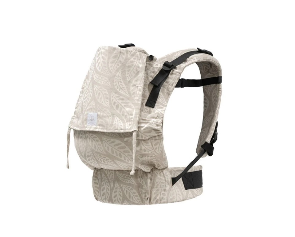 Beige baby carrier with leaf pattern.