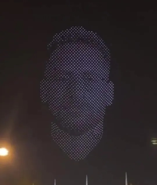 A huge hologram of his face lit up the sky