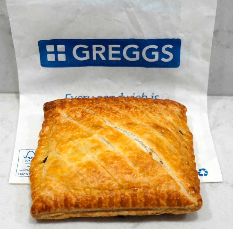 a pastry is sitting on a bag that says greggs