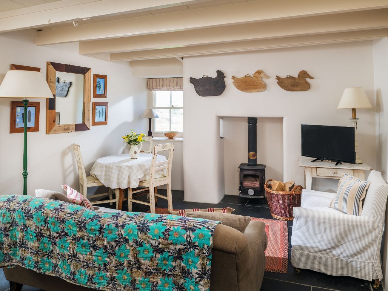 The quaint living room features a log burner and traditional decor