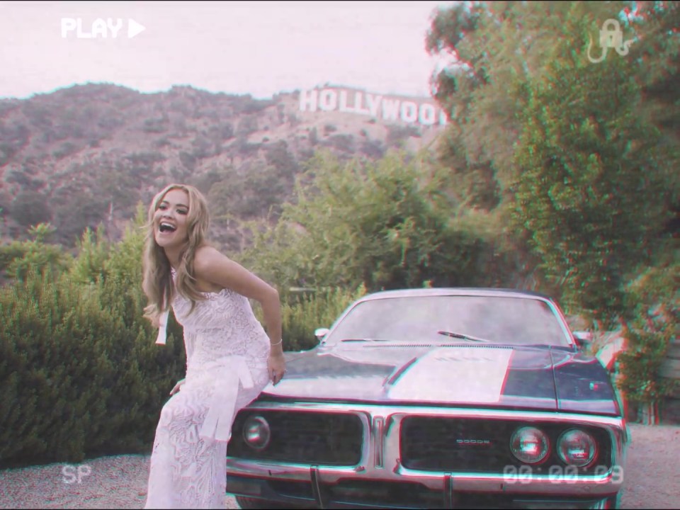 Rita posed on a car parked up outside LA's iconic Hollywood sign