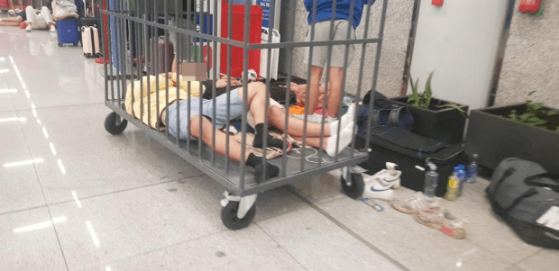 Exhausted passengers sleeping in a trolley in Palma Airport