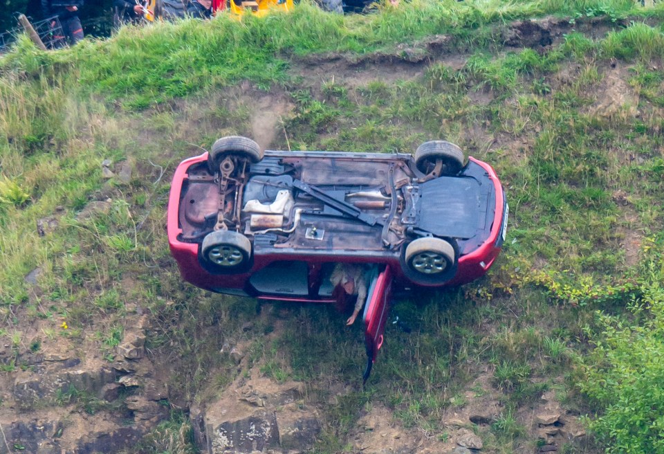 The red car plummeting over the cliff edge