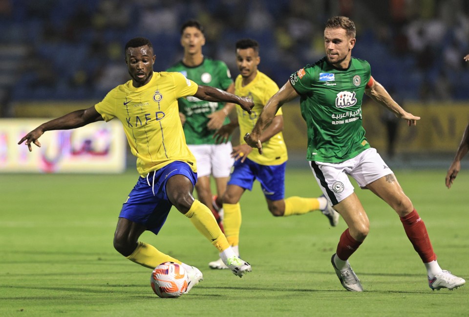 Jordan Henderson of Al-Ettifaq and Ghislain Konan of Al Nassr battle for possession