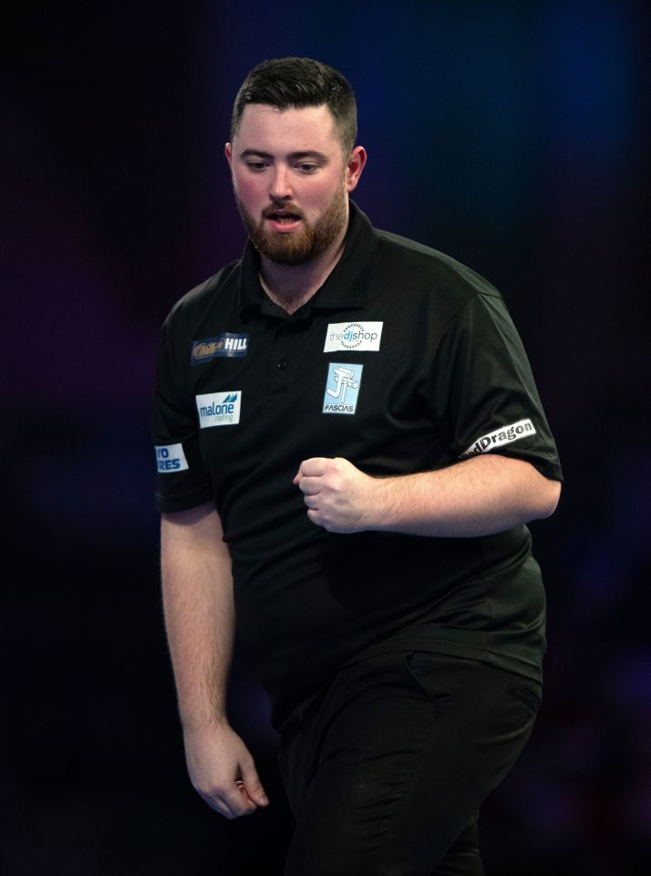 Luke Humphries celebrates during a darts match.