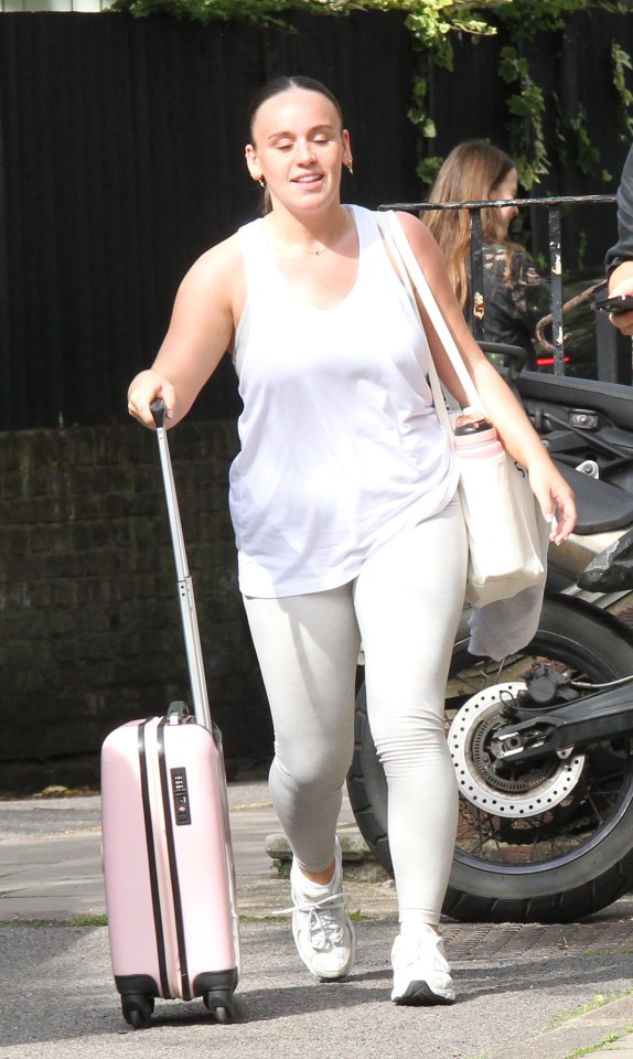 Ellie Leach was a vision in white, accessorising with a baby pink wheelie bag