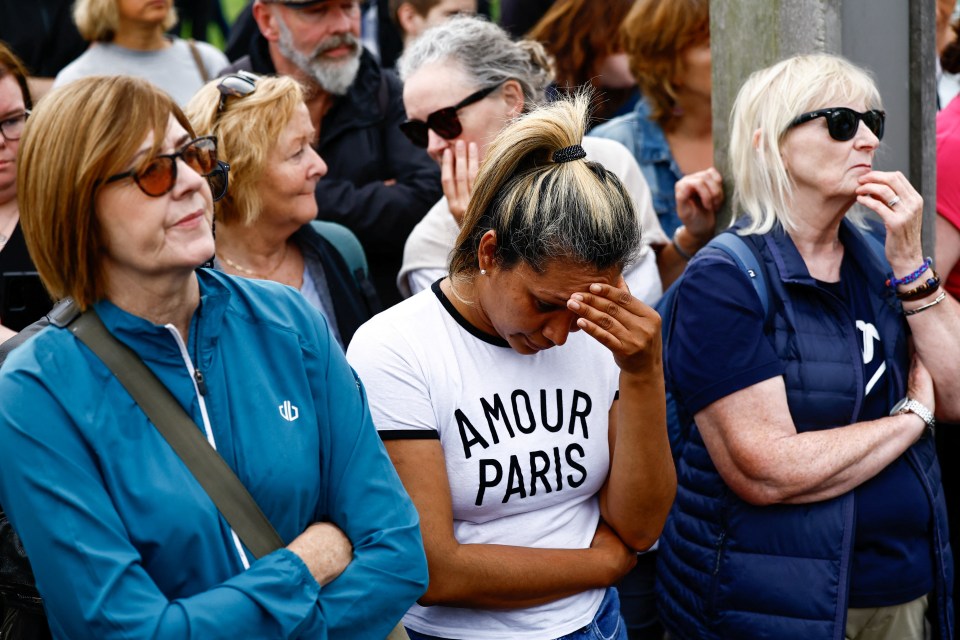 A fan buries her head in her hands as she is overcome by emotion