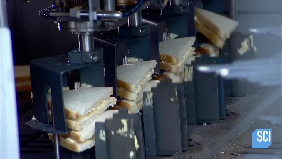 The sandwiches are placed on top of each other by a robotic arm