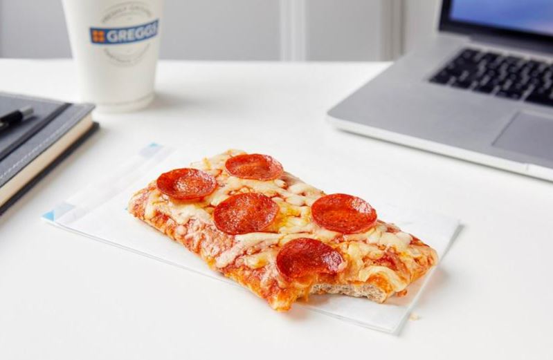 a slice of pepperoni pizza next to a laptop