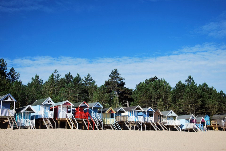 Tourists can rent one of the many multicoloured beach huts