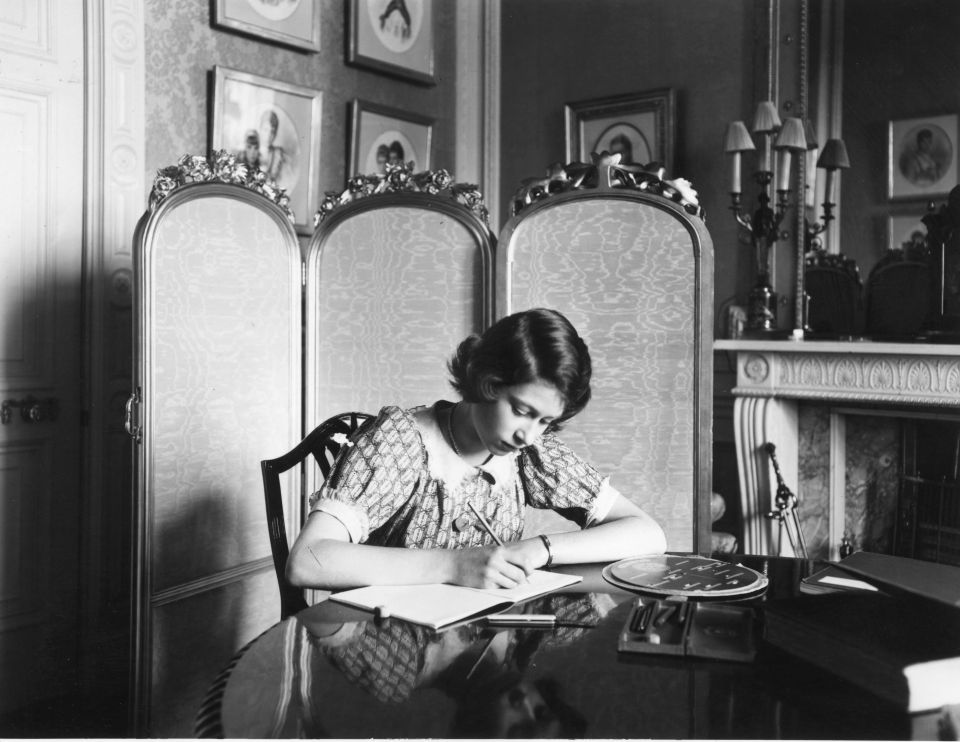 Then-Princess Elizabeth working on her studies at a desk in Windsor Castle