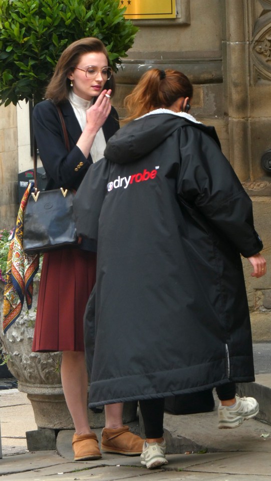 Sophie looked relaxed in slippers as she smoked what looks like a cigarette in between takes