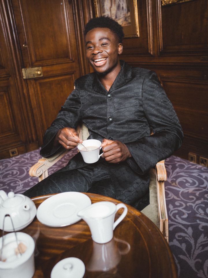 Bukayo Saka posed while drinking a cup of tea