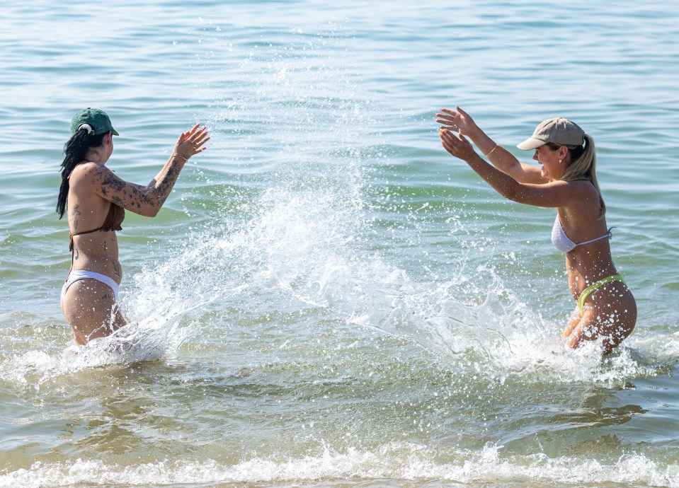 Vanessa McIntyre and Maddie Sykes cool off in the sea at Brighton Beach