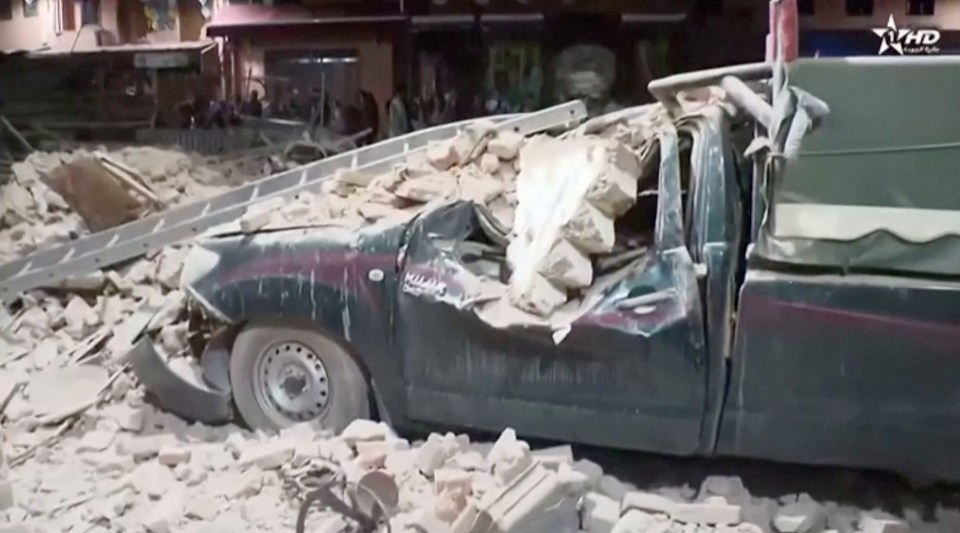 A vehicle was completely crushed by falling rubble dislodged by the earthquake