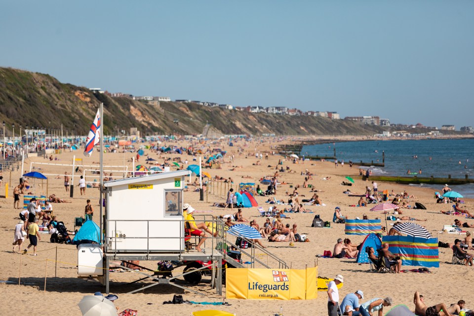 Lifeguard monitoring the beach at Boscombe from the lifeguard tower on a sunny summer day.