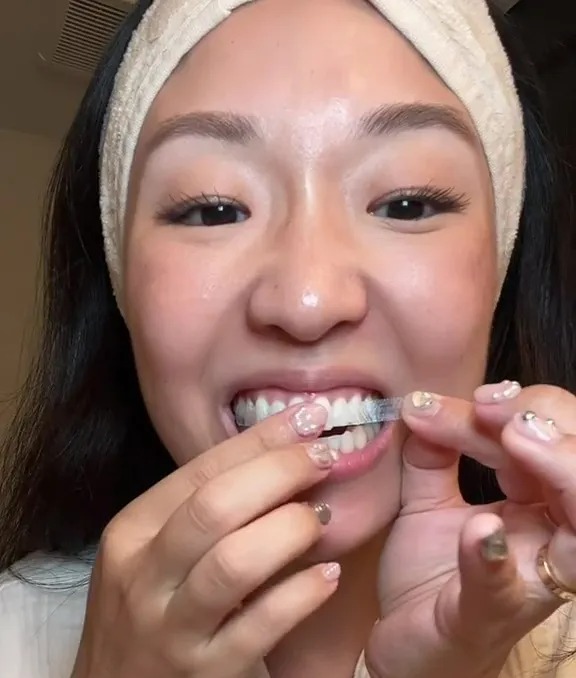 After flossing her teeth, she put the strips on