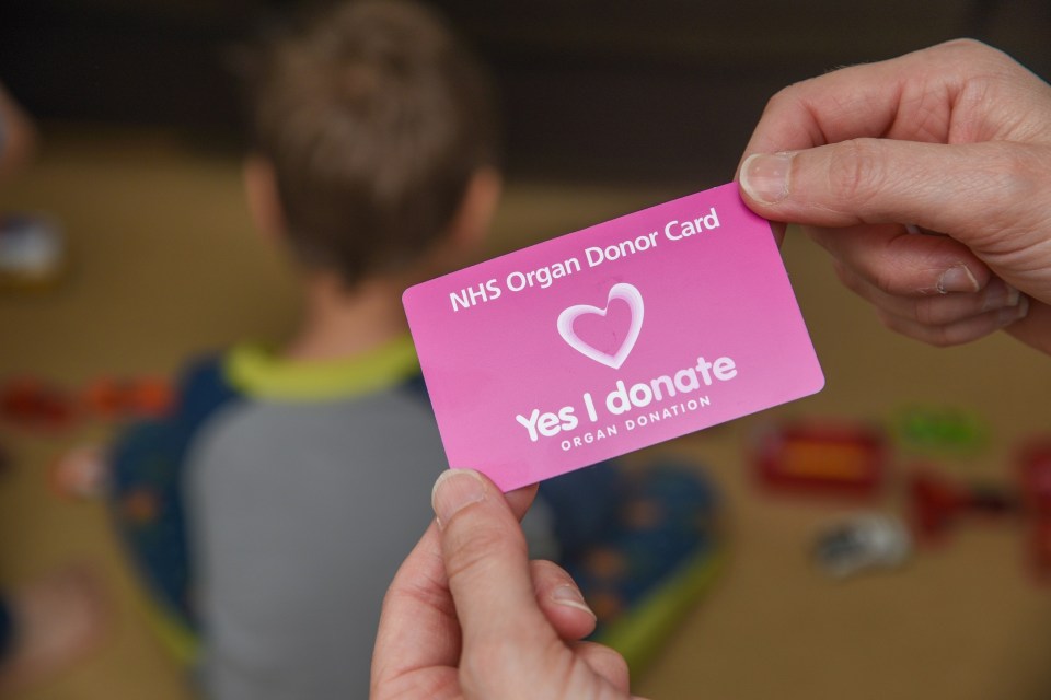 NHS organ donor card in hand.