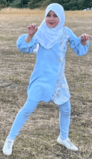 The new images show the playful schoolgirl dancing in a field dressed in a blue hijab