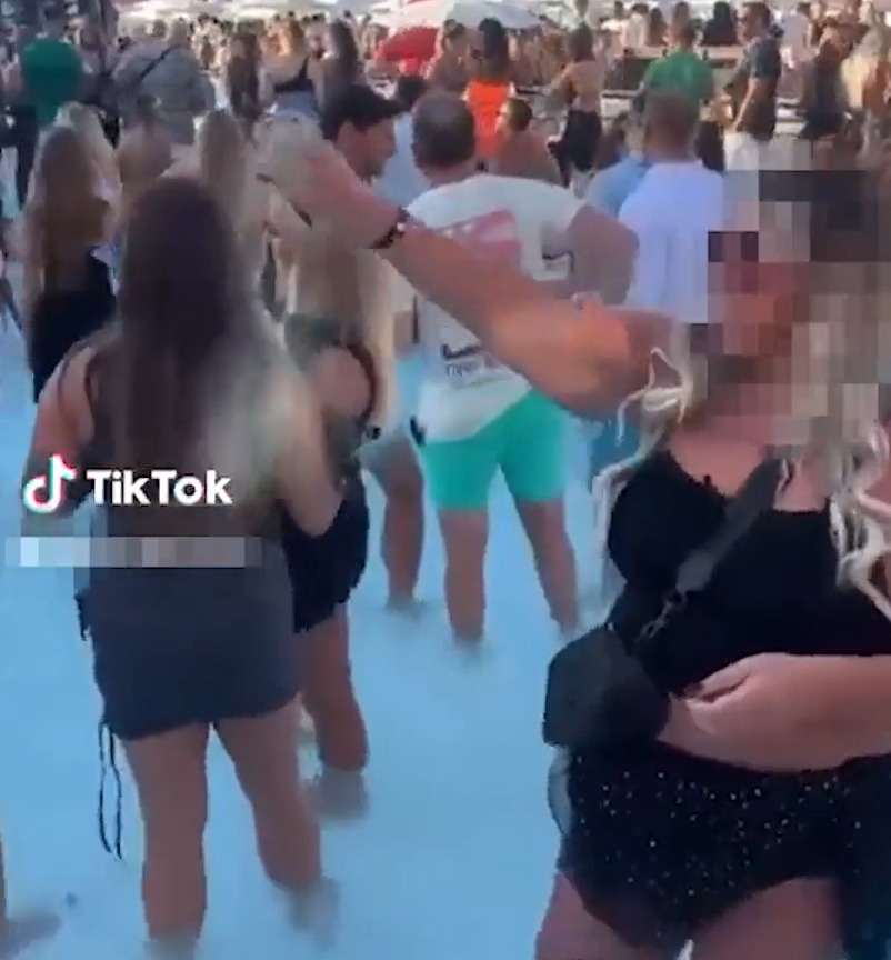 The venue appears to be brimming with revellers partying in front of the stage as the woman empties her 'brother's ashes' into the pool