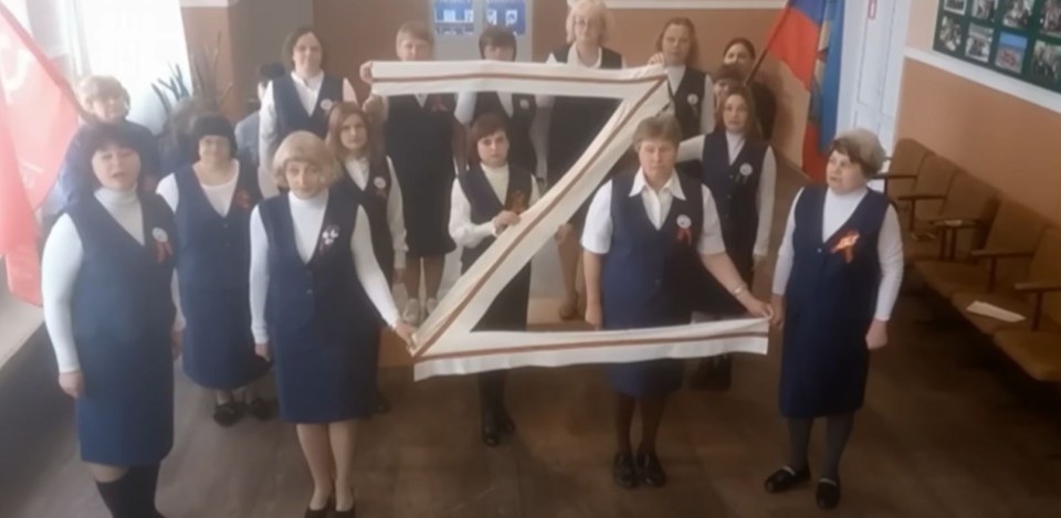 Russian school staff holding up the pro-Russian propaganda motif 'Z'