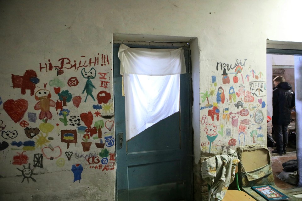 Drawings on the wall of a school basement where Russian occupiers held civilians hostage in northern Ukraine