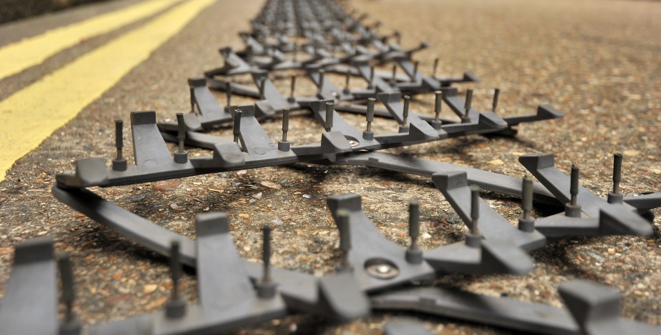 A police stinger left on top of a patrol car fell off and punctured the tyres of four passing vehicles