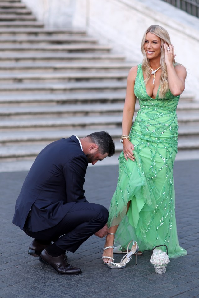 Rahm knelt down to help Kelley with her high heels ahead of the Ryder Cup Gala