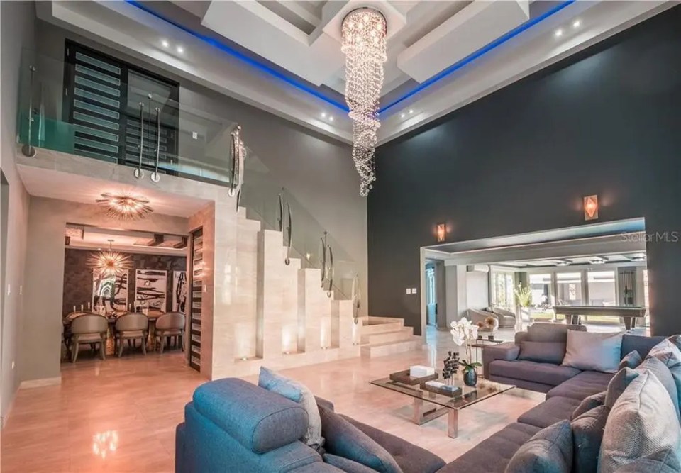 The stunning living room boasts high ceilings and plenty of space