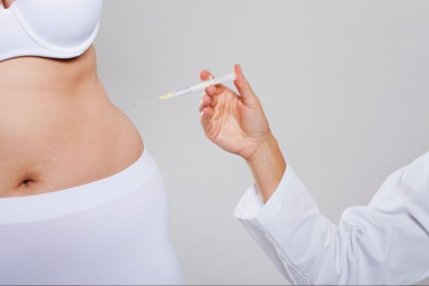 a woman is getting an injection in her stomach