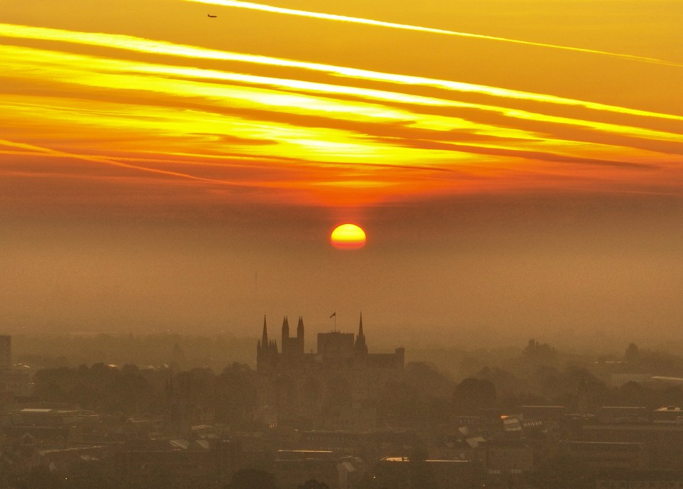 The sun rises above a layer of mist and fog behind Peterborough Cathedral on Friday