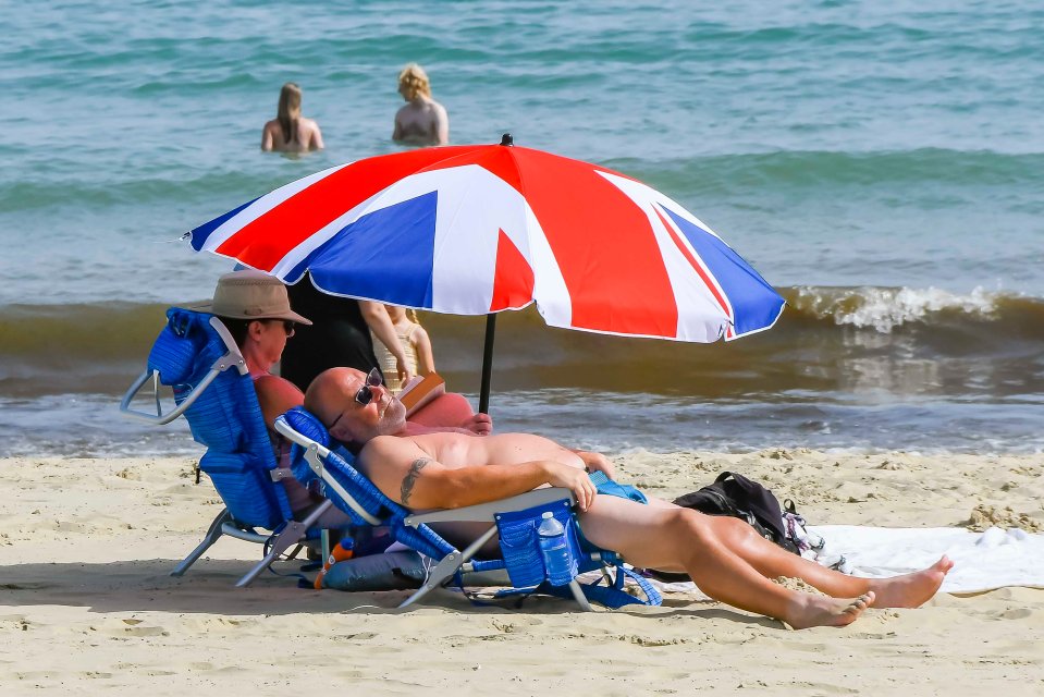 Sunbathers in Weymouth, Dorset lapping up the sun, relaxing by the shore