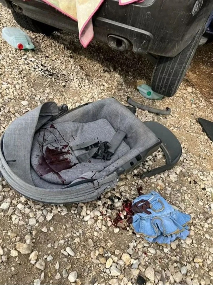 A baby's car seat and child's dress seen covered in blood in the aftermath of the horrific Hamas attack