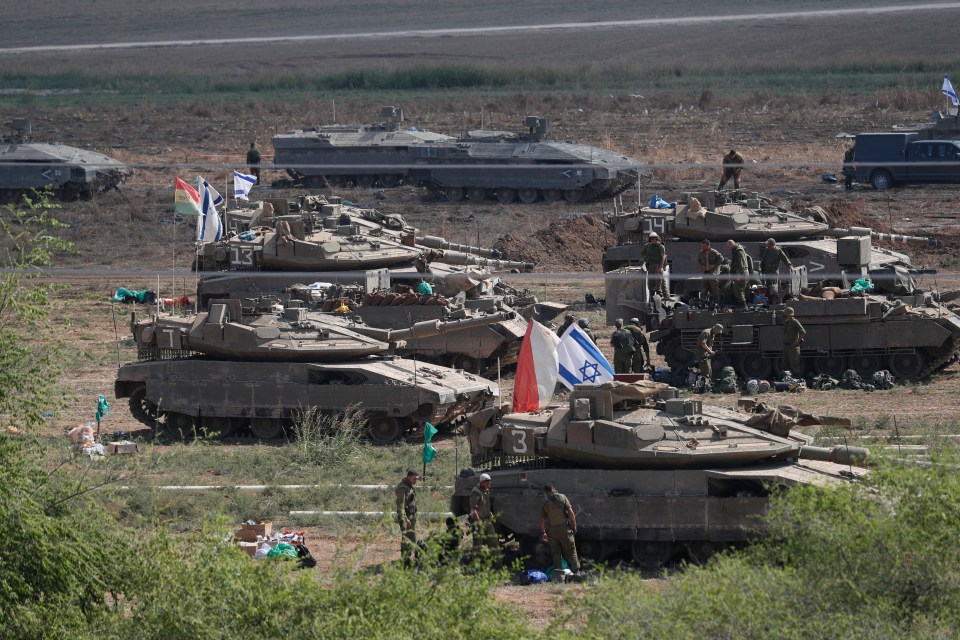 Israeli troops with ‘Merkava’ battle tanks muster at a gathering site at an undisclosed location along the borderline with Gaza