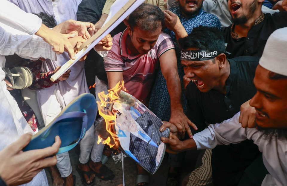 Bangladeshis burn the picture of Israeli Prime Minister Benjamin Netanyahu as they gather in a protest