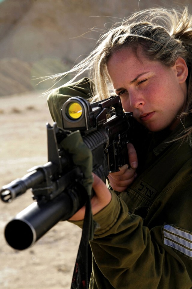 A female Israeli combat soldier of the Caracal light raises her M-16 rifle in 2007