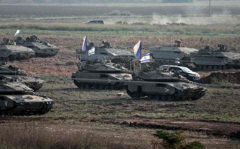 Israeli troops in tanks amass in a field near the southern Israeli city of Ashkelon