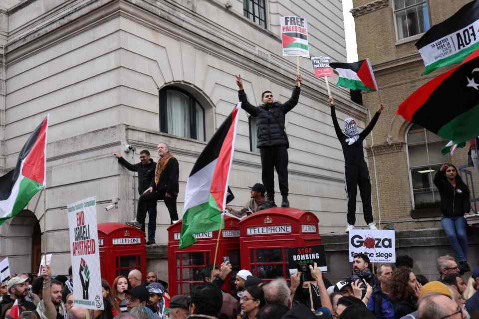 Demonstrators stood on top of a wall to gain a vantage point above the crowd