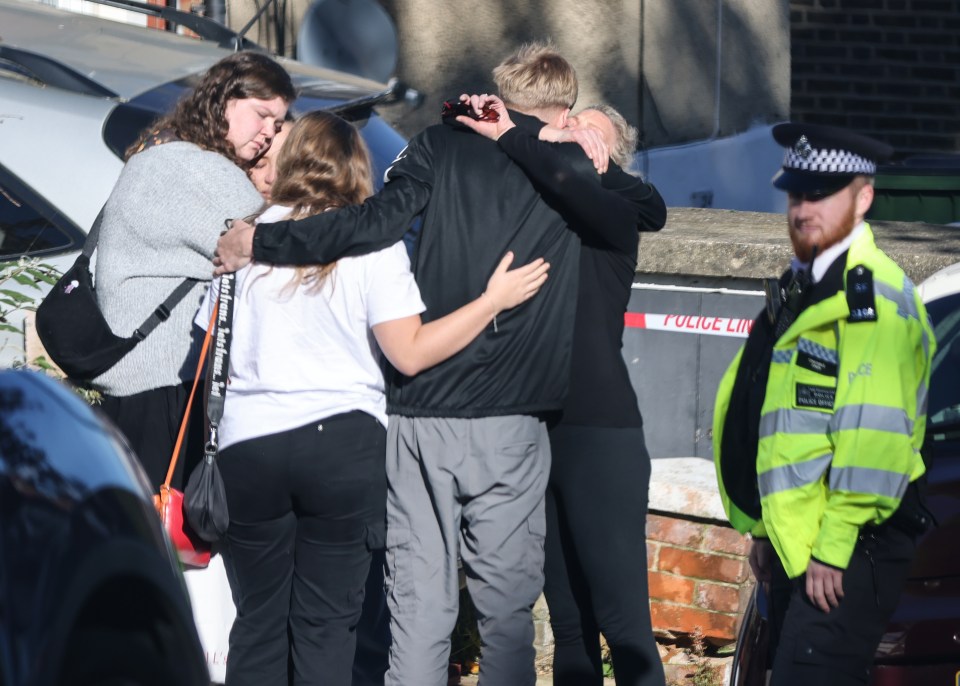 Grieving family and friends gather outside his house