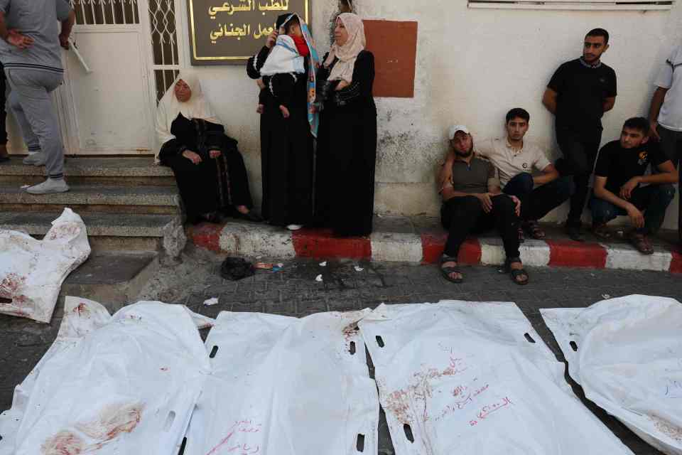 People gather around the bodies of victims of Israeli air strikes