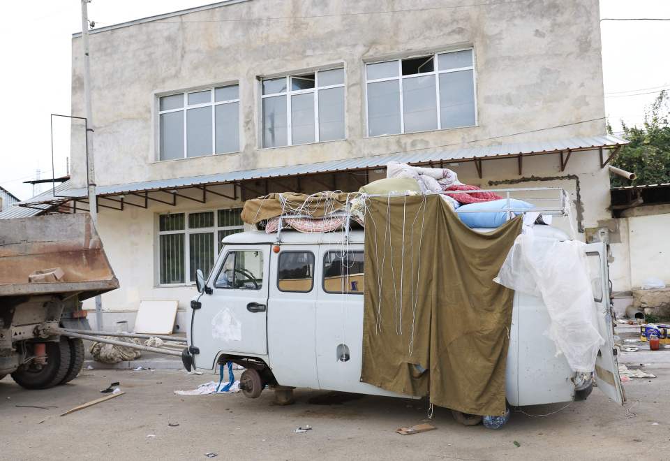 A car loaded with blankets sits abandoned