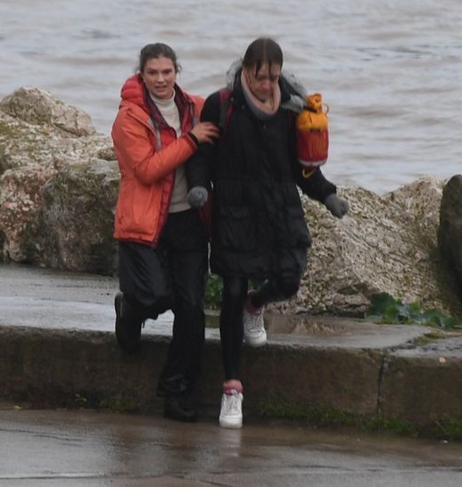 The woman is helped to safety after being pulled from the water