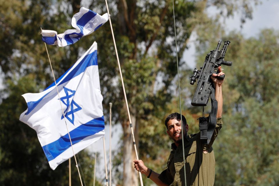 An Israeli soldier gestures as he rides on a military vehicle in the northern town of Kiryat Shmona close to the border with Lebanon.