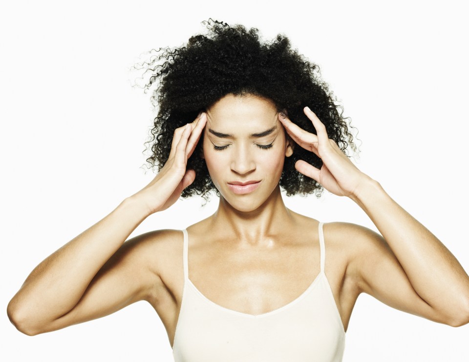 Woman holding her head in her hands, experiencing a headache.