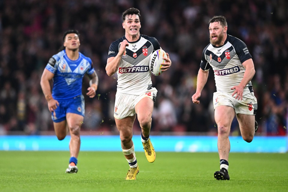 a rugby player wearing a betfred jersey runs with the ball